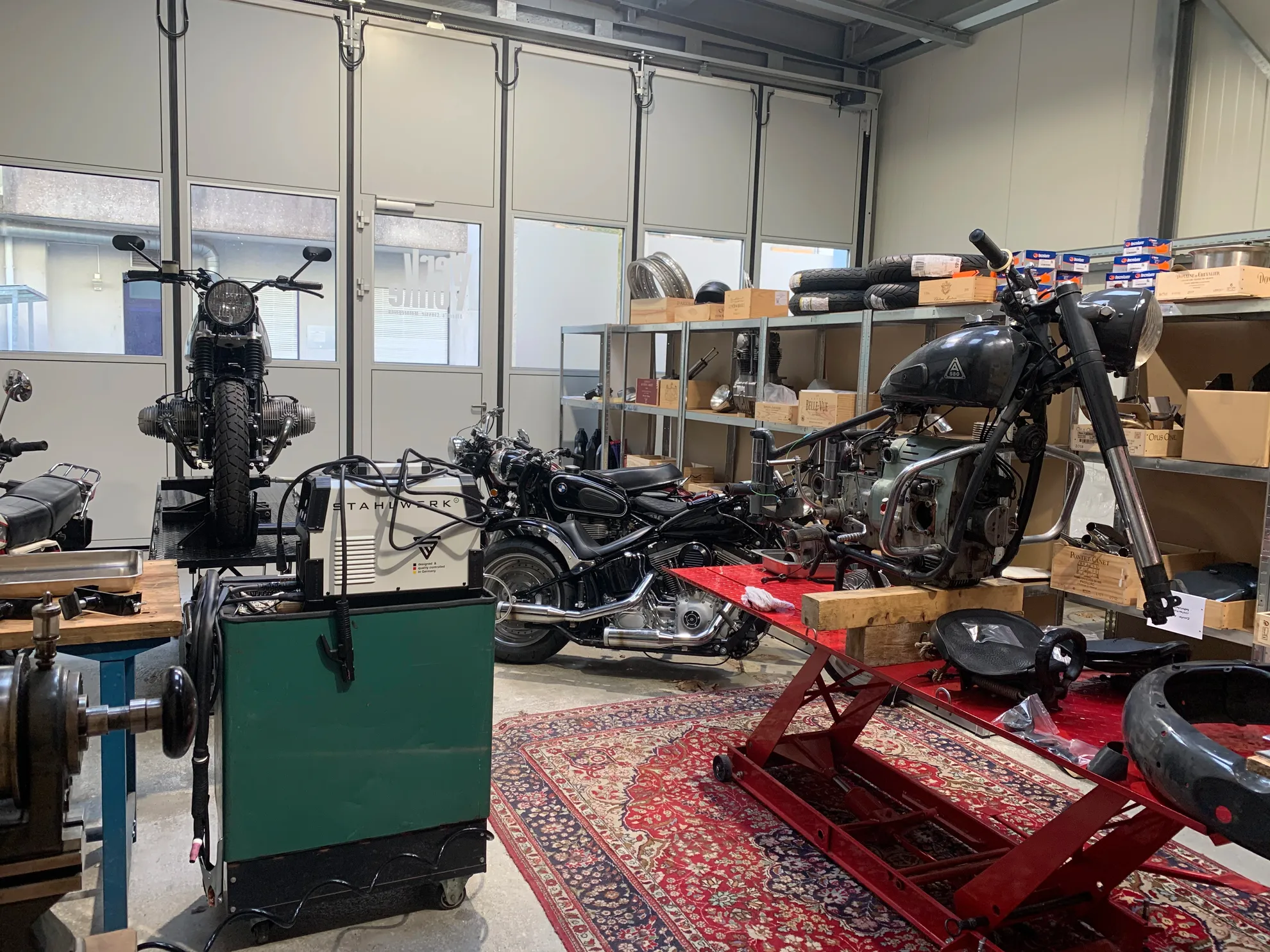 Werkstatt-Innenansicht mit Hebebühnen und Oldtimer Motorräder